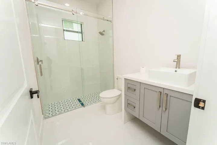 Full bathroom with vanity, a stall shower, and light tile patterned flooring