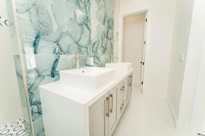 Full bath with double vanity and tile walls