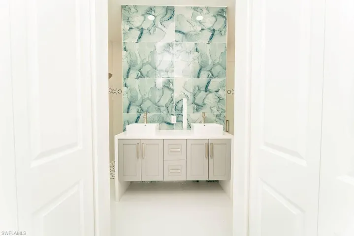 Bathroom featuring double vanity and tile walls