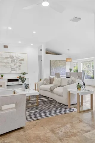 Large spacious living area with a bright and open concept floor plan, recess lighting throughout and new ceiling fans.