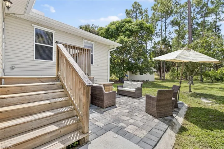 Beautiful patio area with wood deck, ample fruit trees throughout, and a spacious fenced in yard
