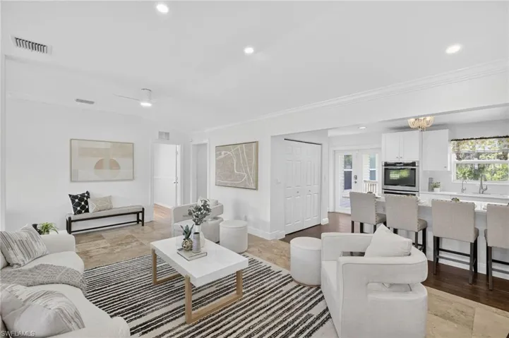 Large spacious living area with a bright and open concept floor plan, recess lighting throughout and new ceiling fans.