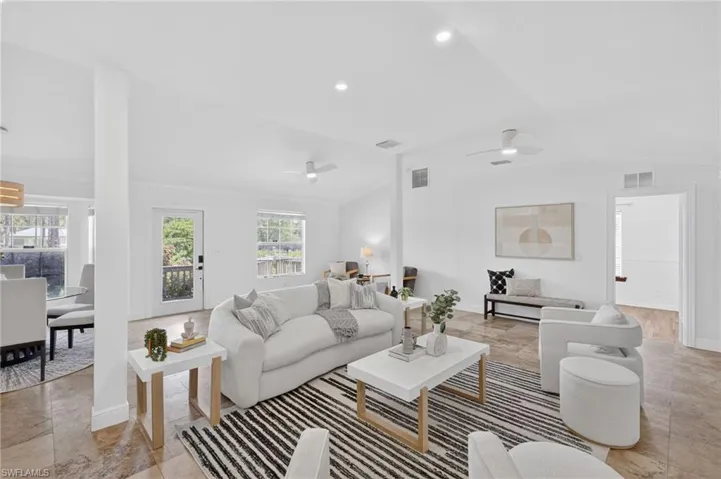 Large spacious living area with a bright and open concept floor plan, recess lighting throughout and new ceiling fans.