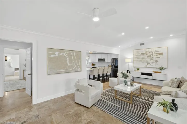 Large spacious living area with a bright and open concept floor plan, recess lighting throughout and new ceiling fans.