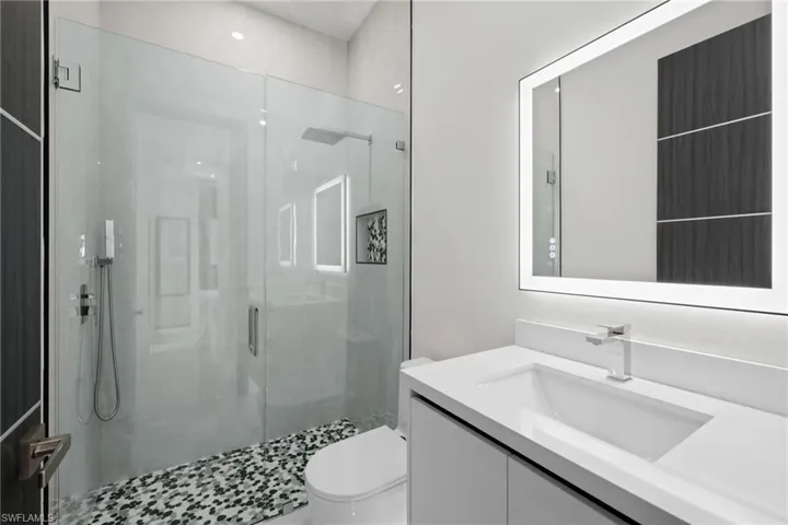 Full bathroom with a shower stall, vanity, and toilet