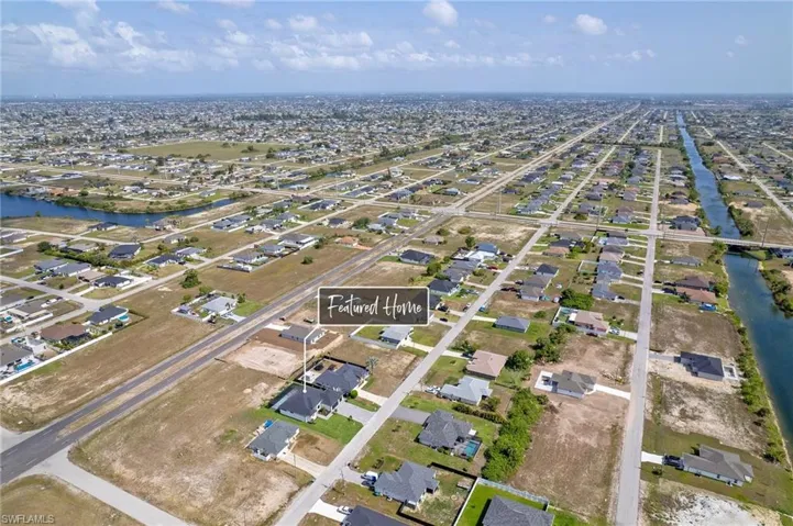 Aerial view of property and surrounding area with nearby suburban area