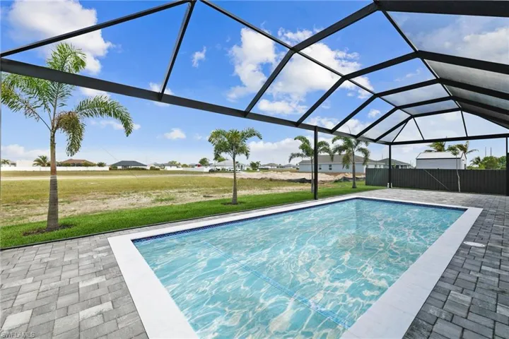 Swimming pool featuring a lawn, a patio, and glass enclosure