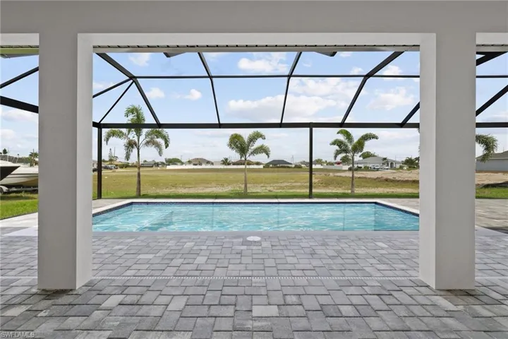 Swimming pool featuring a patio area, a lanai, and a lawn