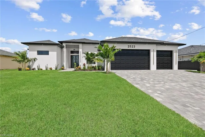 Prairie-style home with decorative driveway, an attached garage, and stucco siding