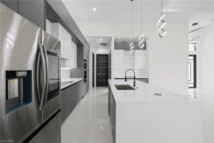 Kitchen with appliances with stainless steel finishes, modern cabinets, a sink, open shelves, and recessed lighting