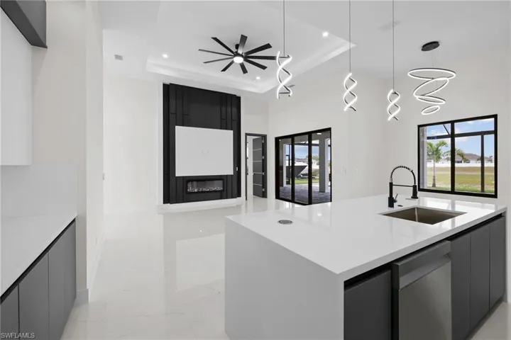 Kitchen featuring a sink, recessed lighting, stainless steel dishwasher, modern cabinets, and light marble finish flooring