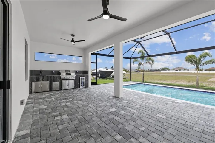 Outdoor pool featuring ceiling fan, a patio, a lanai, and a yard