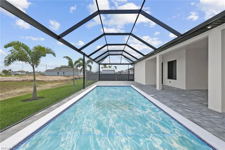 Swimming pool featuring a lawn, a patio area, and a lanai