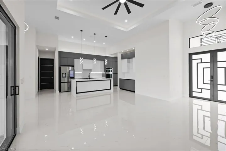 Kitchen featuring stainless steel appliances, modern cabinets, recessed lighting, decorative light fixtures, and open floor plan
