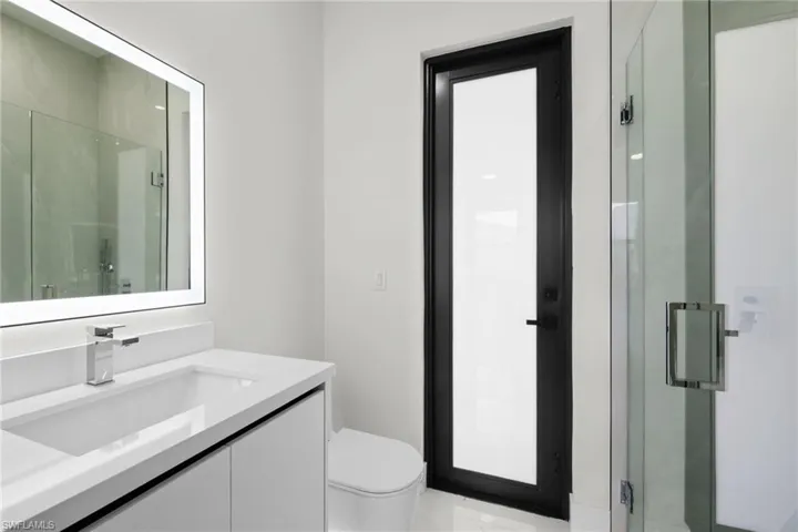 Bathroom featuring vanity, a shower stall, and toilet