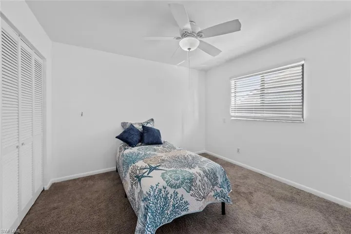 Carpeted bedroom #3 with ceiling fan and a closet