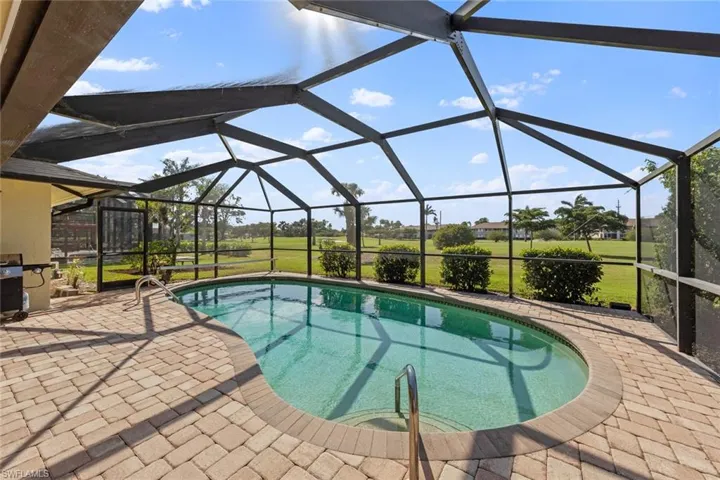 View of pool featuring lanai enclosure and a patio area
