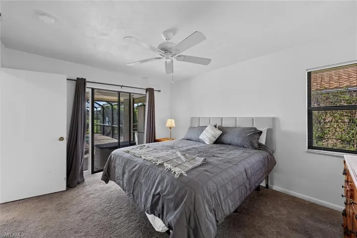 Carpeted bedroom featuring ceiling fan and access to outside