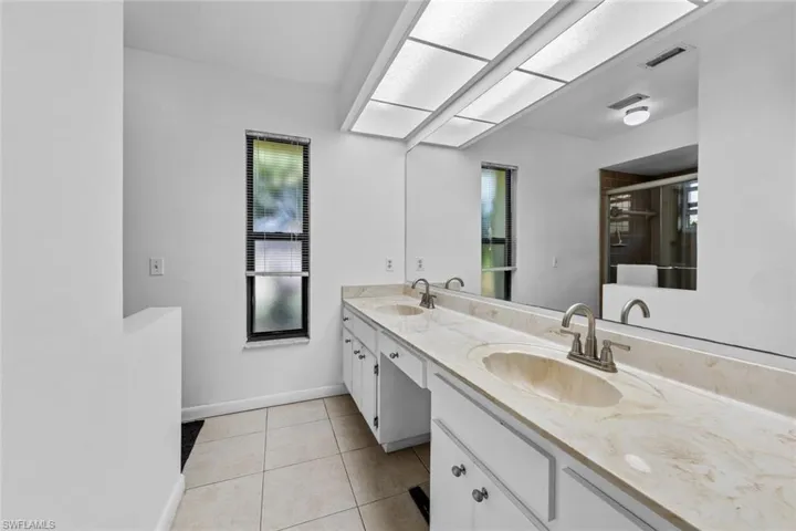 Primary bathroom featuring vanity, tile patterned floors, and a shower with shower door