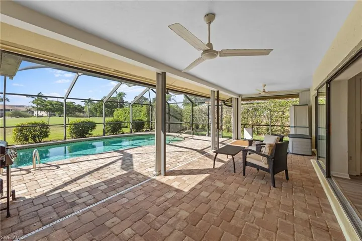 View of swimming pool featuring a patio, ceiling fan, and a lanai