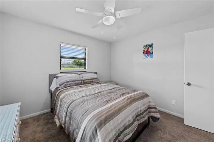 Bedroom #2 with ceiling fan and dark colored carpet