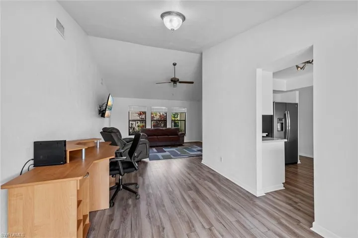 Formal dining room or Office space featuring light wood-type flooring and vaulted ceiling
