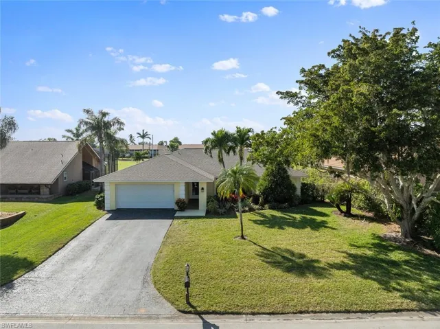 Ranch-style house featuring a front lawn and a garage