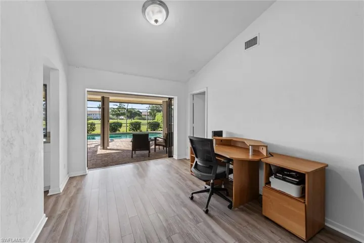 Formal dining room or Office space featuring light wood-type flooring and vaulted ceiling