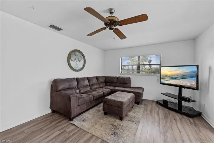 Living room with light wood-type flooring and ceiling fan