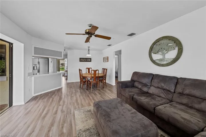 Living room with ceiling fan and light hardwood / wood-style floors