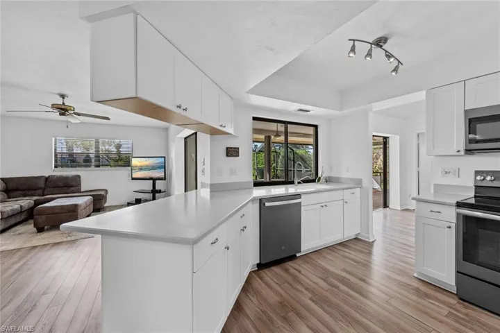 Updated kitchen featuring white cabinetry, kitchen peninsula, and appliances with stainless steel finishes