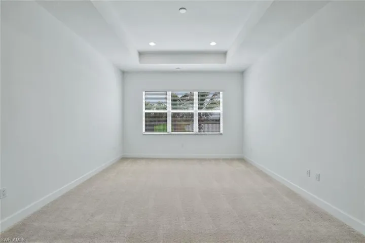 Master bedroom with a raised ceiling