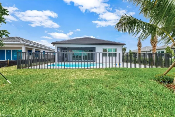 Back of house featuring a lawn and a fenced in pool