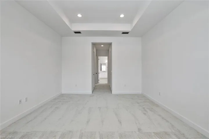 Master bedroom with a raised ceiling
