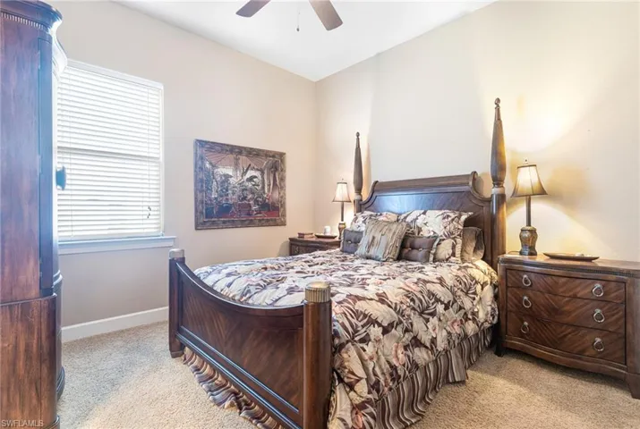 Bedroom featuring a ceiling fan, light colored carpet, and baseboards