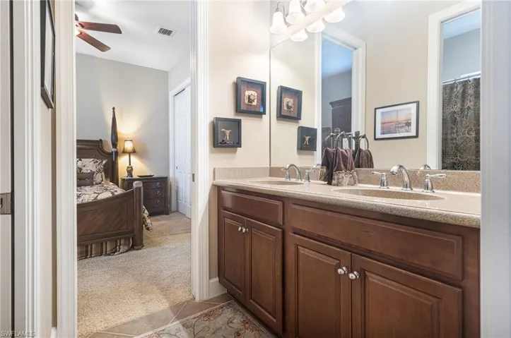 Ensuite bathroom featuring a sink, visible vents, ceiling fan, and ensuite bathroom