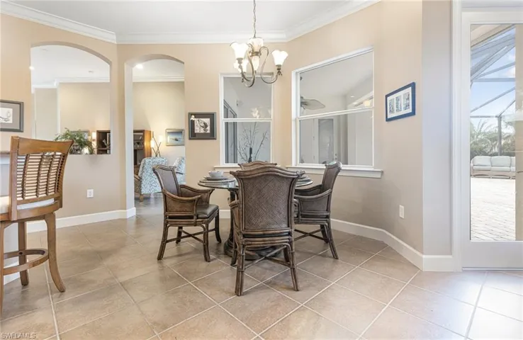 Dining area with light tile patterned floors, a notable chandelier, baseboards, and ornamental molding