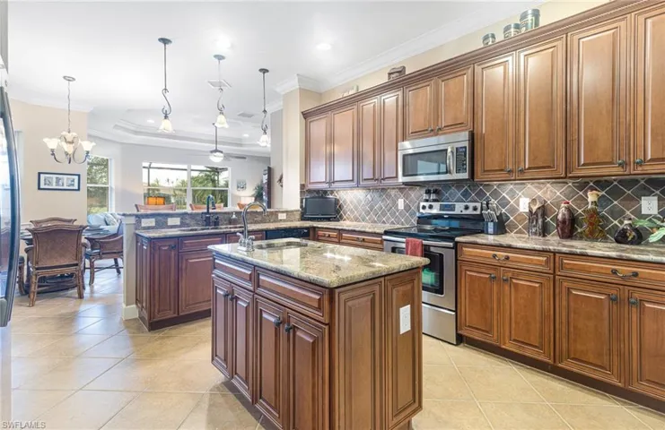 Kitchen featuring decorative backsplash, ornamental molding, and stainless steel appliances