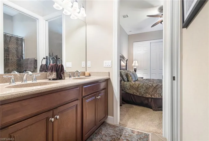 Ensuite bathroom featuring a sink, visible vents, ceiling fan, and ensuite bathroom
