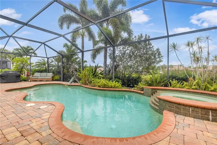 View of swimming pool featuring a patio, area for grilling, a lanai, and a pool with connected hot tub