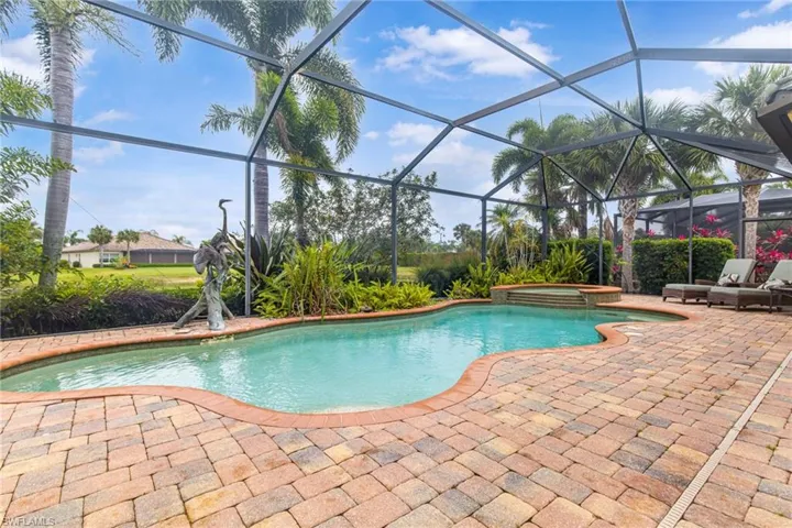 View of swimming pool with a lanai, a pool with connected hot tub, and a patio