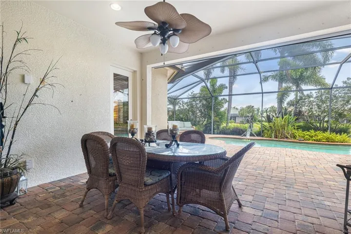 View of patio / terrace with a lanai, a ceiling fan, and an outdoor pool