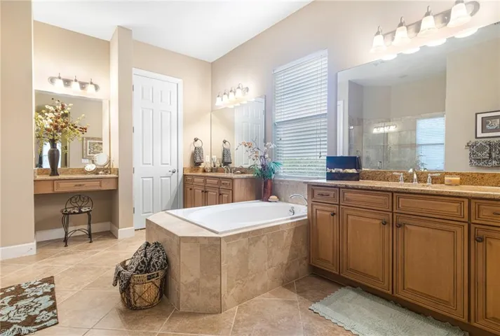 Bathroom featuring a garden tub, tile patterned floors, a stall shower, and a wealth of natural light