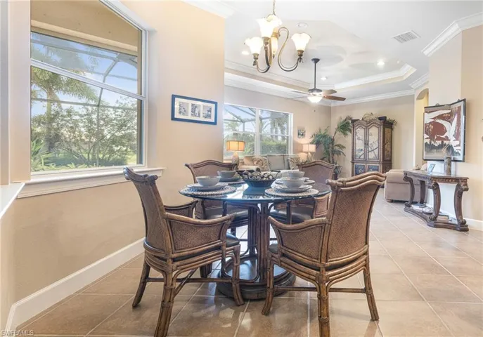 Dining space featuring crown molding, light tile patterned floors, and a healthy amount of sunlight