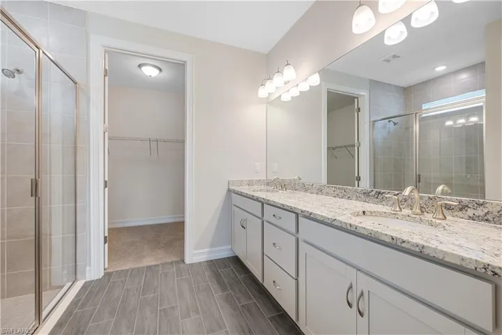 Bathroom featuring a shower with door and vanity