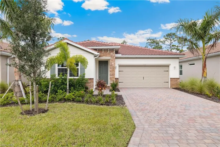 Mediterranean / spanish-style house with a garage and a front yard