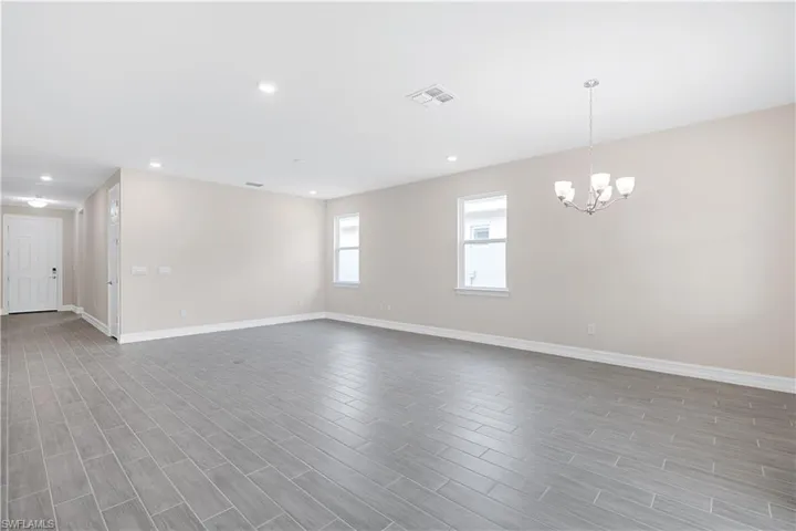 Unfurnished room featuring a notable chandelier and light hardwood / wood-style flooring