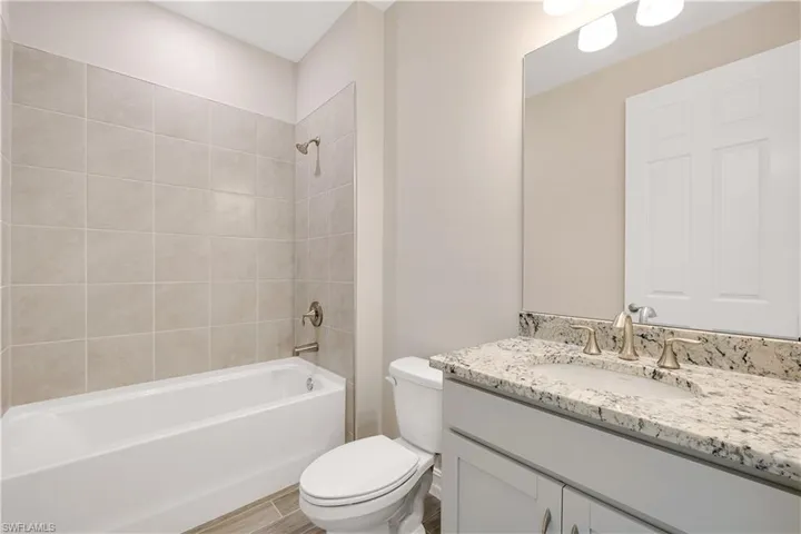 Full bathroom featuring toilet, tiled shower / bath, and vanity