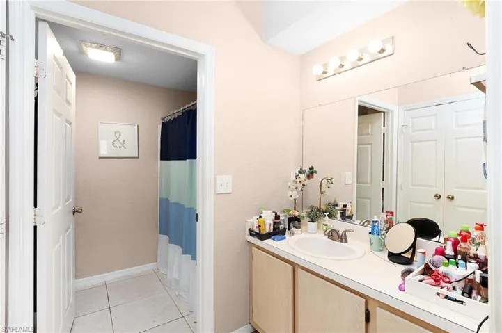 Bathroom with tile patterned flooring, vanity, and a shower / tub