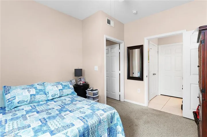 Bedroom with light carpet and ensuite bath